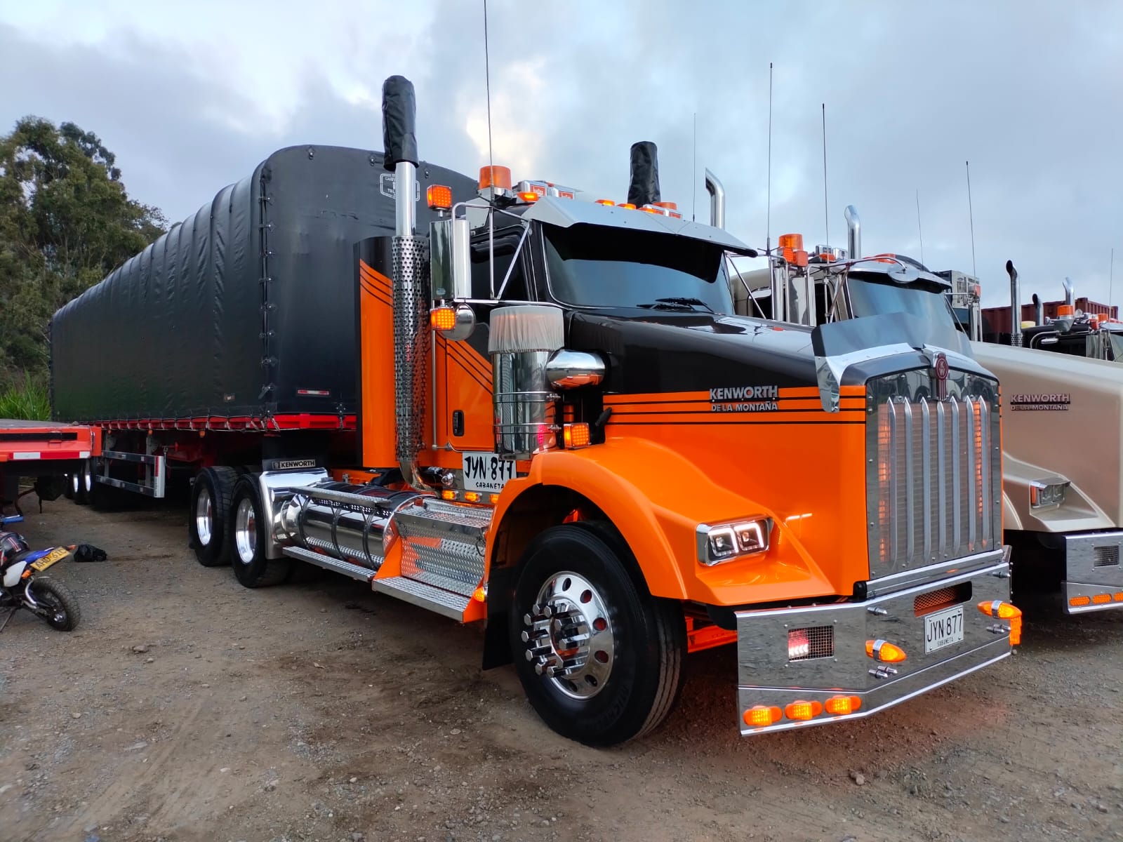 Tractomula Kenworth naranja de Transportes Surtivel junto a la flota