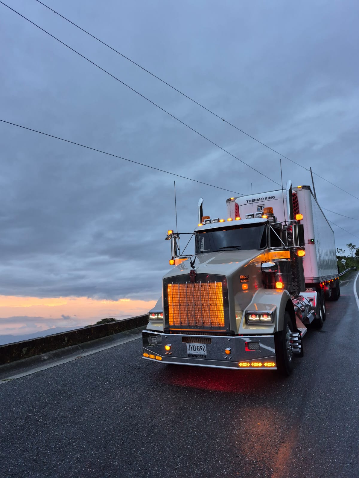 Tractomula Kenworth blanca en ruta nocturna de montaña
