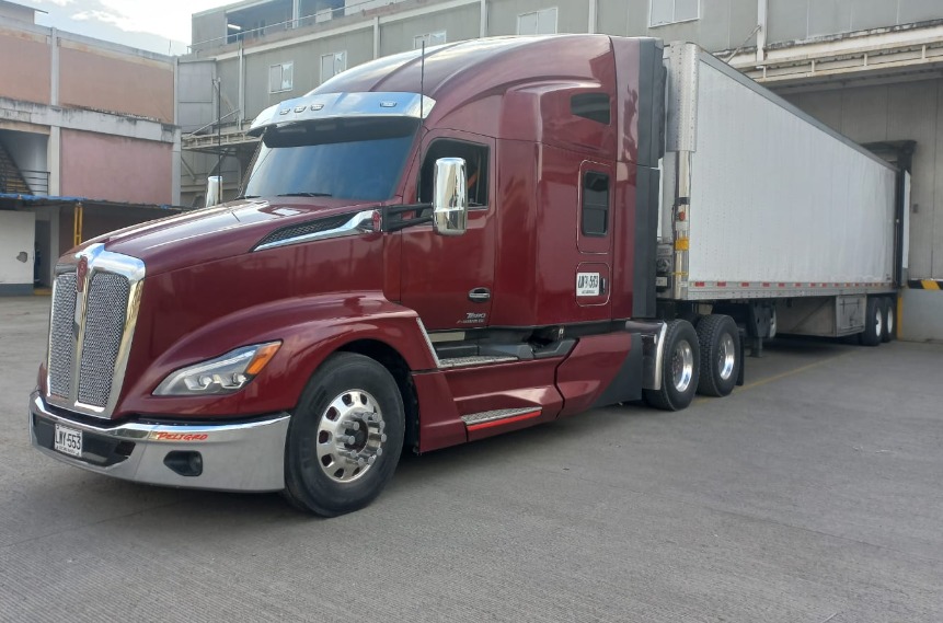Tractomula Kenworth vinotinto en centro de distribución
