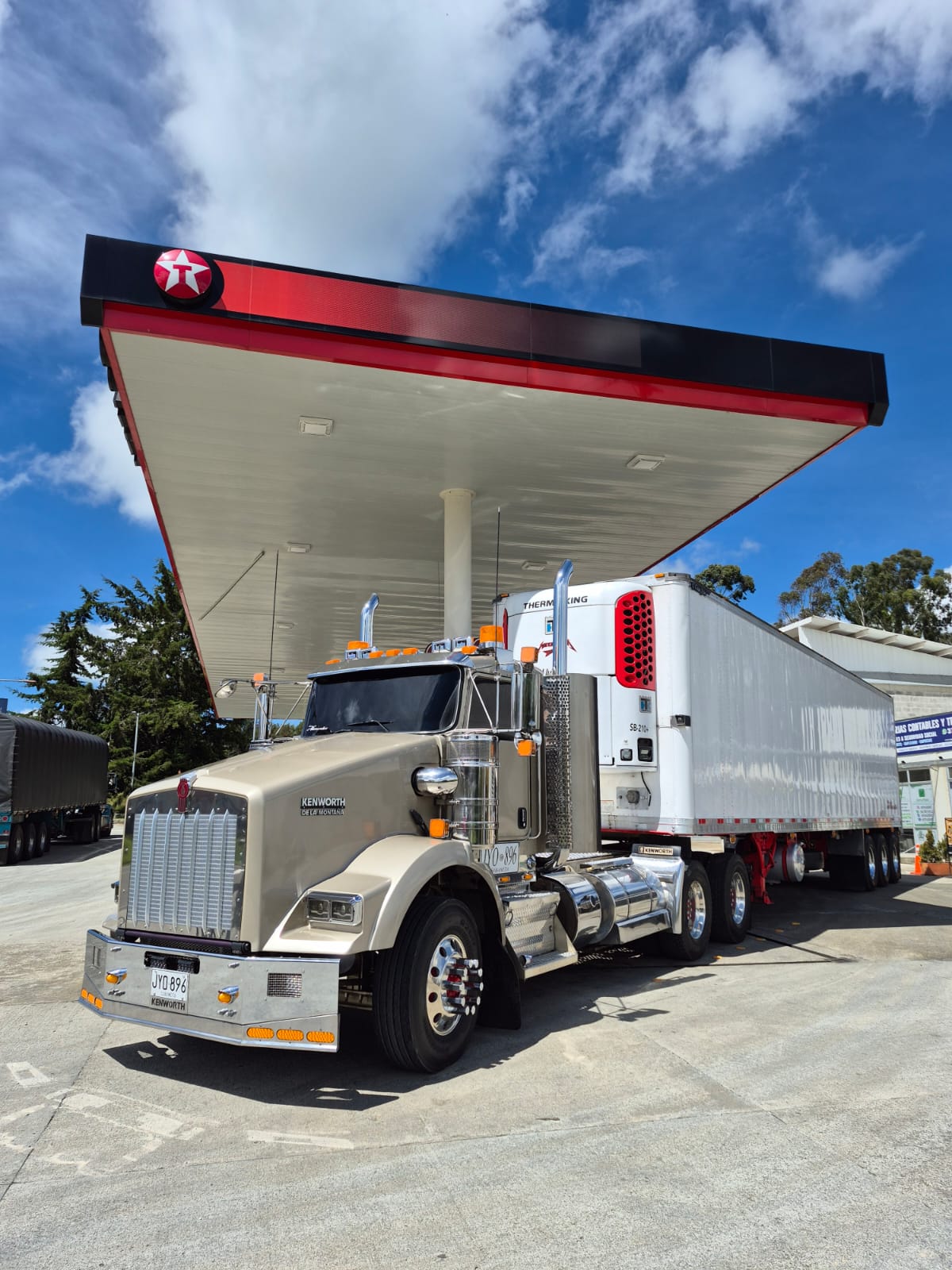 Tractomula Kenworth dorada con tráiler refrigerado